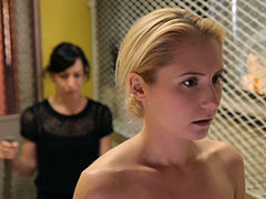 Slender flexible blonde admires herself in the mirror