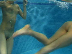 Two funky naked teens play with rubber sex dolls in swimming pool